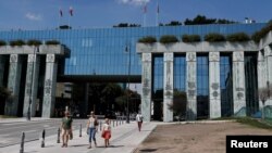 FILE - People walk outside the Supreme Court in Warsaw, Poland, Aug. 13, 2018.