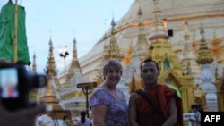 Seorang wisatawan berfoto bersama seorang biksu di Pagoda Shwedagon di Ranggon, Burma (Foto: dok). Arus wisatawan manca negara ke Burma mulai meningkat sejak tahun 2011.