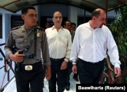 Polisi mengawal Serge Areski Atlaoui (Prancis) dan Nicolaas Garnick Josephus Gerdardus (Belanda) menuju ruang sidang di Tangerang, Banten, 6 November 2006. (Foto: Beawiharta/Reuters)