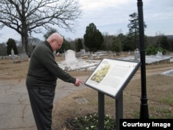 Tom Houck reads a plaque about the history of South-View Cemetery. (Photo Courtesy by Philip Graitcer)