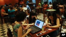 Warga Vietnam menggunakan laptop dan ponsel pintar untuk menjelajah Internet di sebuah kafe di Hanoi. (Foto: Dok)