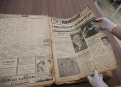 Seorang karyawan di Perpustakaan Nasional menunjukkan halaman depan surat kabar Daily Mail edisi Senin, Februari 1958 yang memperlihatkan pembunuh berantai terkenal Si Ouey di Bangkok, Thailand, Senin, 9 Juli 2019.