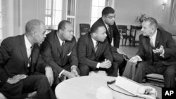 U.S. President Lyndon B. Johnson, right, talks with civil rights leaders in his White House office in Washington, D.C., Jan. 18, 1964. The black leaders, from left, are, Roy Wilkins, executive secretary of the National Association for the Advancement of Colored People (NAACP); James Farmer, national director of the Committee on Racial Equality; Dr. Martin Luther King Jr., head of the Southern Christian Leadership Conference; and Whitney Young, executive director of the Urban League. (AP Photo)