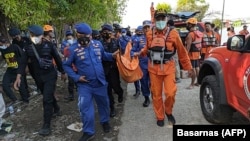 Para petugas Badan Pencarian dan Pertolongan Nasional (Basarnas) membawa jenazah dari perahu yang terbalik di sebuah kawasan wisata di Boyolali, Jawa Tengah, Minggu, 16 Mei 2021. (Foto: Basarnas via AFP)