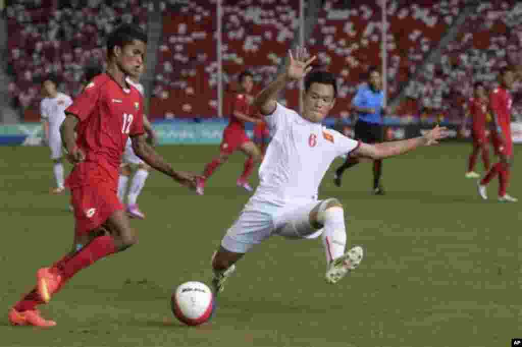 Nguyen Minh Tung of Vietnam (6) tackles Kyaw Zin Lwin of Myanmar in the soccer semi-final at the SEA Games in Singapore Saturday, June 13, 2015. (AP Photo/Joseph Nair)