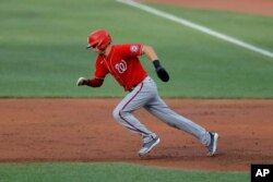 Washington Nationals' Trea Turner tries to steal second base against the Baltimore Orioles during an exhibition baseball game, July 20, 2020, in Baltimore. Turner was caught stealing by catcher Bryan Holaday.