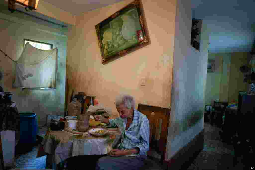 Zenobia Ansualve, 88, eats lunch at her home in Caracas, Venezuela, Aug. 18, 2021. Ansualve, who lives alone and has not left her home since the start of the COVID-19 pandemic, said she lives on $20 a month from a room she owns and rents.