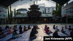 Umat Muslim mengantre untuk menerima barang-barang yang disumbangkan oleh konsulat China di Masjid Cheng Ho di Surabaya pada 6 Mei 2021, menjelang Idul Fitri yang menandai berakhirnya bulan suci Ramadhan. (Foto: AFP/Juni Kriswanto)