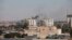 Smoke rises near buildings after heavy fighting between rival militias broke out near the airport in Tripoli, July 20, 2014.