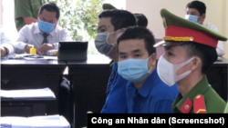 Nhà báo Trương Châu Hữu Danh, giữa, và Nguyễn Thanh Nhã (phía sau) tại phiên toà xét xử hôm 26/10. Bộ Ngoại giao Mỹ kêu gọi Việt Nam trả tự do cho các thành viên nhóm Báo Sạch vừa bị kết án gần 15 năm tù.