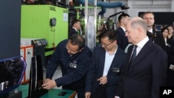 En esta imagen, distribuida por la agencia noticiosa Xinhua, el canciller de Alemania, Olaf Scholz (derecha), visita el Centro de Innovación Asia-Pacífico de la empresa alemana Covestro en Shanghái, el 15 de abril de 2024.