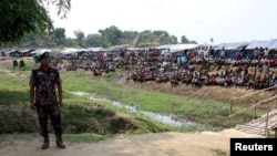 FILE - A soldier stands near the Cox's Bazar refugee camp in Bangladesh, near Rakhine state, Myanmar, during a trip by United Nations envoys to the region, April 29, 2018. 