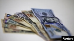 FILE - Brazilian real and U.S. dollar notes are pictured at a currency exchange office in Rio de Janeiro, Brazil.