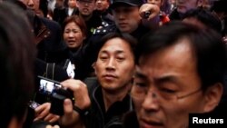 North Korean national Ri Jong Chol, center, is surrounded by media after his arrival at the airport in Beijing, China, March 4, 2017. 