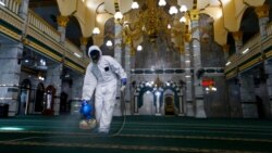 Seorang petugas medis mengenakan pakaian hazmat menyemprotkan disinfektan di sebuah masjid di tengah wabah virus corona, di Jakarta, 13 Maret 2020. (Foto: Reuters)