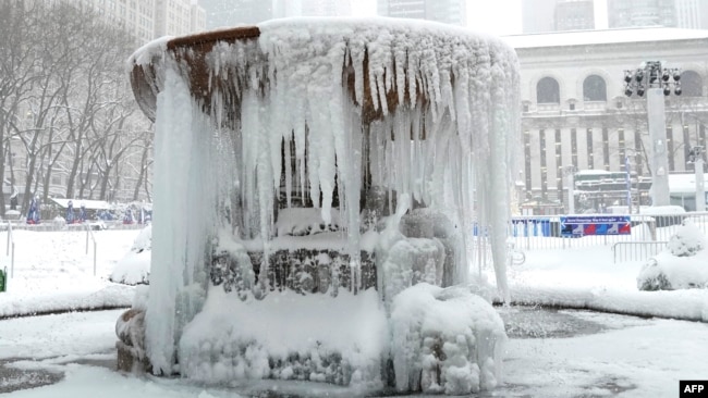 This photo is of a frozen fountain in New York City's Bryant Park during a winter storm on February 1, 2021. (Photo by TIMOTHY A. CLARY / AFP)