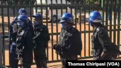 Des policiers montent la garde devant le tribunal de première instance d'Harare lors de la comparution de l'opposant Jacob Ngarivhume et du journaliste Hopewell Chin'ono le 22 juillet 2020.