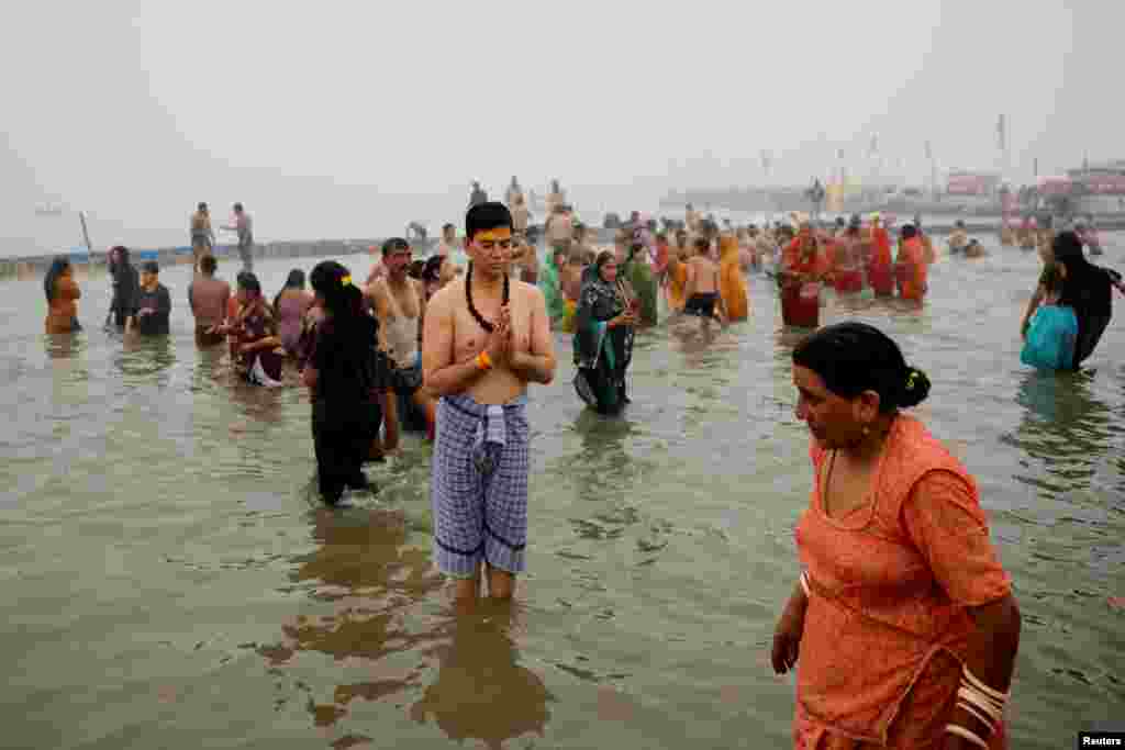 A devotee prays as he takes a holy dip at Sangam, the confluence of the Ganges, Yamuna and Saraswati rivers, during the &quot;Maha Kumbh Mela&quot;, or the Great Pitcher Festival, in Prayagraj, India, Jan. 13, 2025.