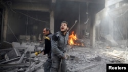 Para anggota pertahanan sipil Suriah memerika kerusakan pasca serangn udara pasukan pemerintah atas posisi pemberontak di Douma, Ghouta timur (foto: dok). 