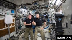 FILE - One-year mission crew members Scott Kelly of NASA, left, and Mikhail Kornienko of Roscosmos their 300th consecutive day in space, Jan. 21, 2016. The pair headed for home March 1 after spending a total of 340 days in space. 