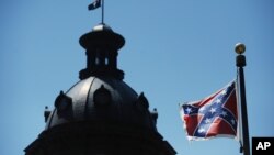 Bendera kondererasi berkibar di gedung Capitol kota Columbia, S.C., 19 Juni 2015.