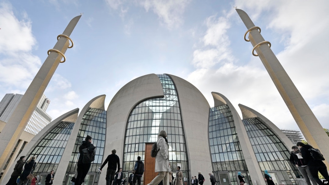 FILE - In this Oct. 3, 2017 file photo people stand outside the central DITIB mosque on the "Day of Open Mosques" in Cologne. The German city of Cologne will start permitting mosques to broadcast muezzin calls for prayer, the city said. 