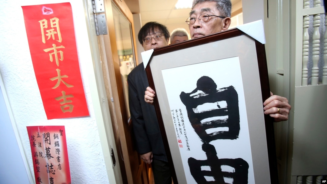 台北銅鑼灣書店創辦人林榮基手持台灣公民參與協會理事長何宗勳寫的“自由”字畫。