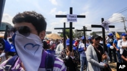 Los manifestantes en contra del gobierno se unen a una procesión de las Estaciones de la Cruz el viernes santo, con carteles que exigen la liberación de presos políticos en Managua, Nicaragua.