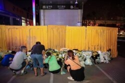 河南郑州市民在被黄色围栏围起来的地铁5号线车站前献花悼念水灾死难者。（2021年7月26日）