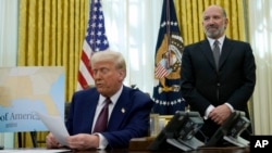 Howard Lutnick, President Donald Trump's choice to serve as commerce secretary, listens as Trump speaks after signing an executive order in the Oval Office of the White House, Feb. 13, 2025, in Washington.