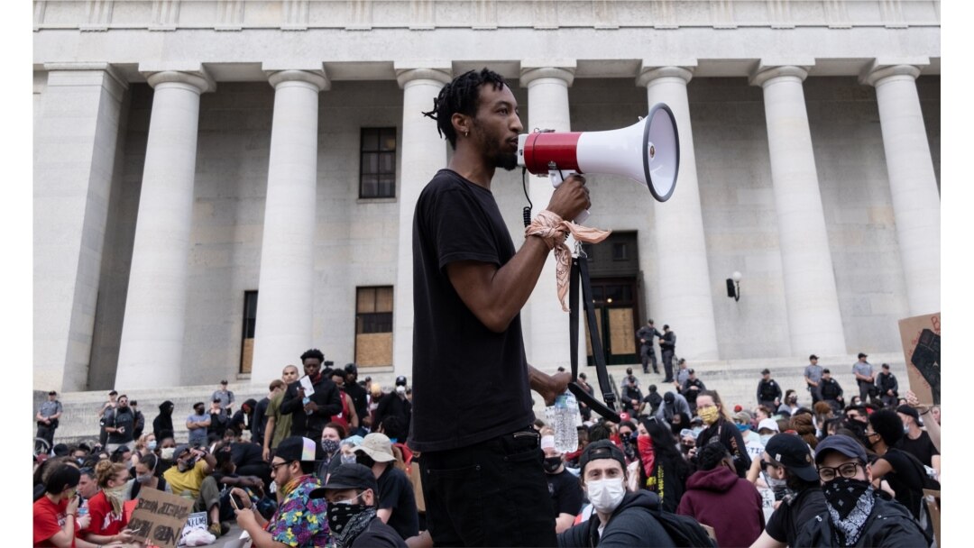 Protesters listen to a man speak as they gather peacefully in front of the Ohio Statehouse in Downtown Columbus, Ohio, June 1, 2020, to protest the death of George Floyd.