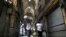 Men carry their goods through mostly closed Tehran's Grand Bazaar, Iran, March 17, 2020. The new coronavirus ravaging Iran is cutting into celebrations marking the Persian New Year, known as Nowruz.