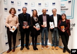 From left, Author Fiona Mozley with her book "Elmet," Author Paul Auster with his book "4321," Author Emily Fridlund with her book "History of Wolves," Author Mohsin Hamid with his book "Exit West," Author George Saunders with his book "Lincoln in the Bardo" and Author Ali Smith with her book "Autumn" during a photocall with all six shortlisted authors of the 2017 Man Booker Prize for Fiction, in London, Oct. 16, 2017.