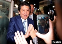 Japan's Prime Minister Shinzo Abe, leader of the Liberal Democratic Party, greets his supporters after making a speech at an election campaign rally in Tokyo, Japan, Oct. 20, 2017.