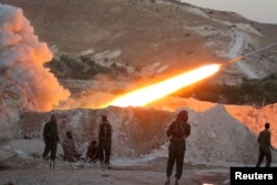 FILE - Free Syrian Army fighters launch a rocket from Halfaya town in Hama province toward forces loyal to Syria's President Bashar al-Assad stationed in Zein al-Abidin mountain, Syria, Sept. 4, 2016.