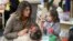 First lady Melania Trump watches as children form objects from Play-Doh at Joint Base Elmendorf-Richardson, Alaska, Nov. 10, 2017.