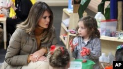 First lady Melania Trump watches as children form objects from Play-Doh at Joint Base Elmendorf-Richardson, Alaska, Nov. 10, 2017.