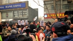 2015年12月22日，北京市二中院外面，支持者向国际媒体展示浦志强无罪的大字标语。（美国之音叶兵拍摄）