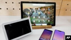 The Google Home Hub, left, Pixel Slate, center, and two new smartphones are displayed in New York, Tuesday, Oct. 9, 2018. (AP Photo/Richard Drew)