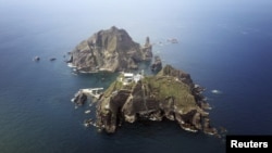 FILE - A set of remote islands, called Dokdo in Korean and Takeshima in Japanese, as seen from a helicopter.
