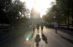 Orang-orang berolahraga menyusuri East Capitol Street menuju gedung Capitol AS saat penyebaran Covid-19 berlanjut di Washington, AS, 6 April 2020. (Foto: REUTERS/Leah Millis)