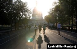 Orang-orang berolahraga menyusuri East Capitol Street menuju gedung Capitol AS saat penyebaran Covid-19 berlanjut di Washington, AS, 6 April 2020. (Foto: REUTERS/Leah Millis)
