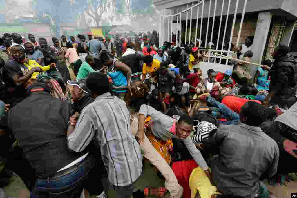 Residents desperate for a planned distribution of food for those suffering under Kenya's coronavirus-related movement restrictions push through a gate and create a stampede, at a district office in the Kibera slum of Nairobi.