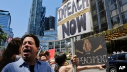 FILE - Protesters rally outside a Trump hotel to call for the impeachment of President Trump, July 2, 2017, in New York.