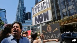 Protesters rally outside a Trump hotel to call for the impeachment of President Trump, July 2, 2017, in New York.