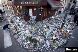 People mourn outside "Le Carillon" restaurant a week after a series of deadly attacks in Paris, Nov. 22, 2015.