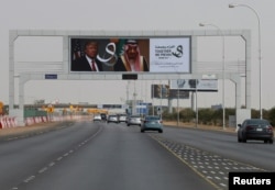 U.S. President Donald Trump's and Saudi Arabia's King's Salman bin Abdulaziz Al Saud's photos are seen with flags of both countries on airport road as part of celebrations to welcome United States President Donald Trump, in Riyadh, Saudi Arabia, May 19, 2