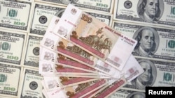 照片顯示100盧布和100美元的鈔票- 資料圖