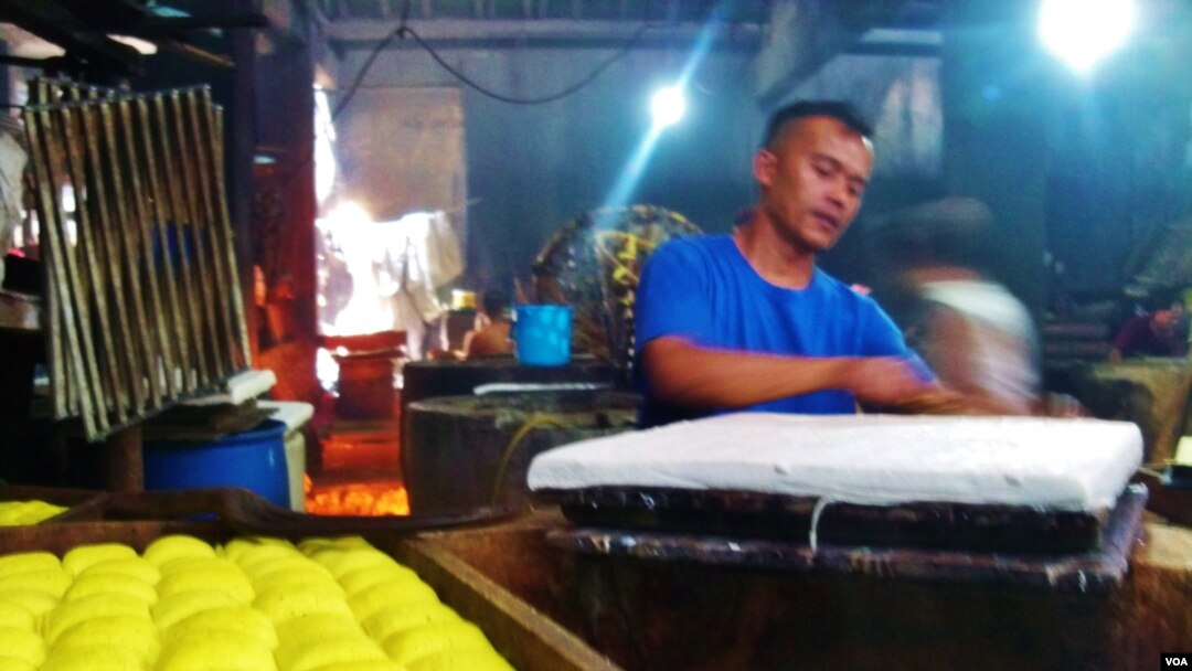 Seorang perajin tahu di Sentra Produksi Tahu Cibuntu, Bandung sedang menyelesaikan produksi tahu. Perajin tahu tempe mengeluhkan kenaikan harga kedelai impor dari Amerika (foto: VOA/Wulan).