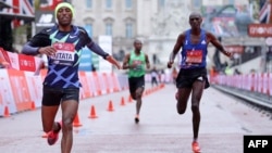 Ethiopia's Shura Kitata (L) beats Kenya's Vincent Kipchumba (R) and Ethiopia's Sisay Lemma (C) at the finish of the elite men's race of the 2020 London Marathon in central London on October 4, 2020. - This year's London marathon, an elite-athlete only eve
